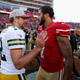 Aaron Rodgers of the Green Bay Packers talks with Colin Kaepernick, then of the San Francisco 49ers, after their game at Levi’s Stadium on Oct. 4, 2015, in Santa Clara, Calif. (Ezra Shaw/Getty Images)